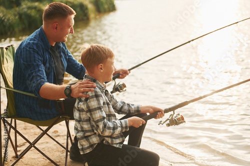Resting and having fun. Father and son on fishing together outdoors at summertime