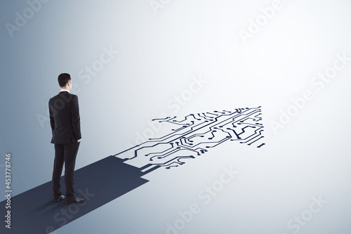 Businessman standing on abstract circuit arrow sketch on white background with mock up place. Success and digital transformation concept. photo