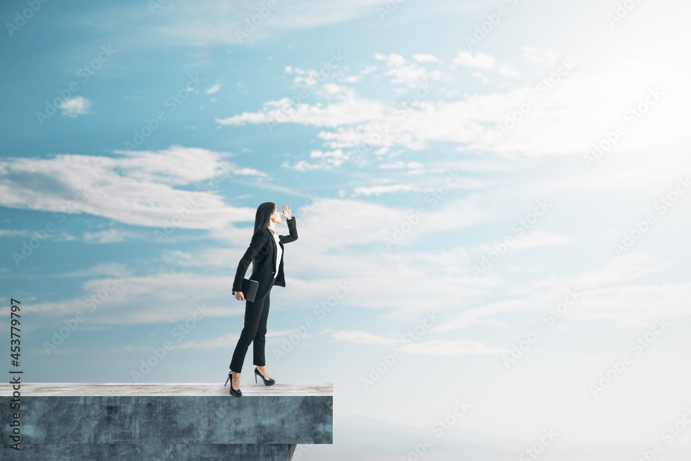 Businesswoman on abstract concrete edge looking into the distance on creative bright sky background with mock up place. Future, tomorrow and success concept.