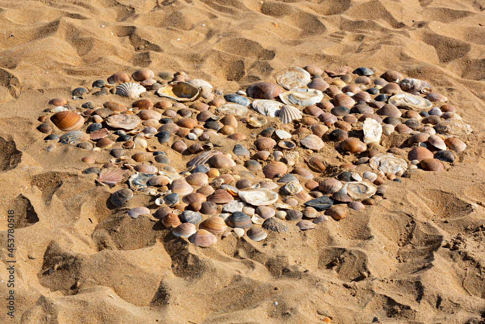 Conchas formando un corazón en la arena de la playa. Conchas formando un corazón en la arena de la playa.