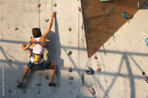 the girl climbs on the climbing wall