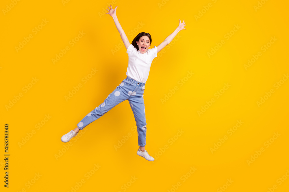 Full body photo of young excited girl happy positive smile jump up isolated over yellow color background
