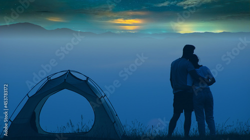 Photography The man and woman standing on a mountain top at the campsite