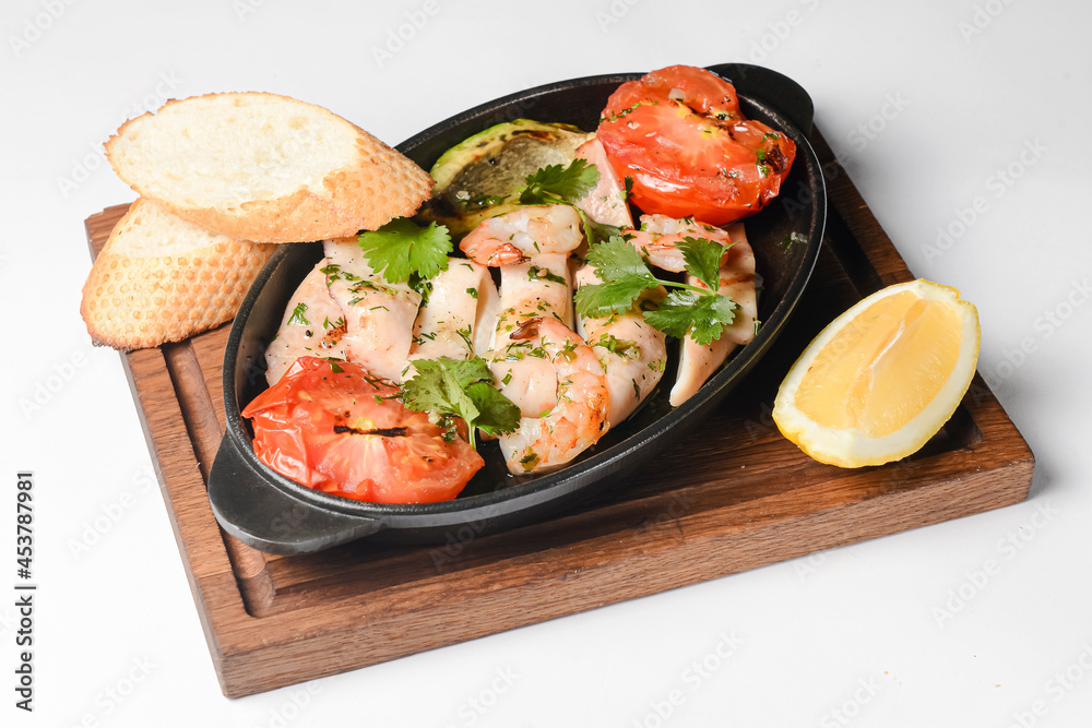 Frittata with shrimp and vegetables in a pot over white background. Fish casserole with veggies
