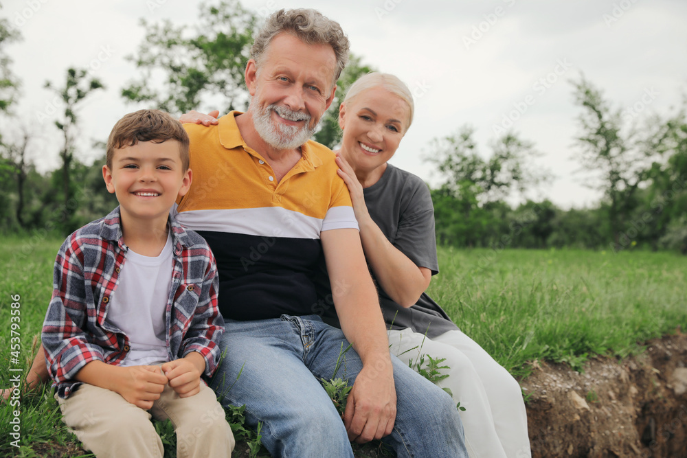 Fototapeta premium Cute little boy and grandparents spending time together in park