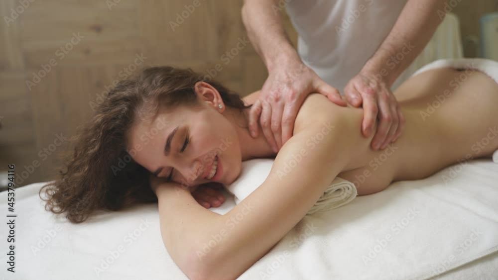 Charming Pleasant Lady Relax During Spa Massage In Beauty Center, Lying On Stomach, Having Rest After Working Day. Wellness, Therapy, Massage, Spa Concept. Charming Pleasant Lady Relax During Spa Massage In Beauty Center, Lying On Stomach, Having Rest After Working Day. Wellness, Therapy, Massage, Spa Concept.