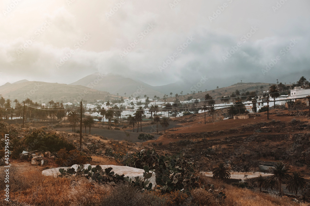 Fototapeta premium Photograph of the town of Haria in Lanzarote among the clouds at sunset.