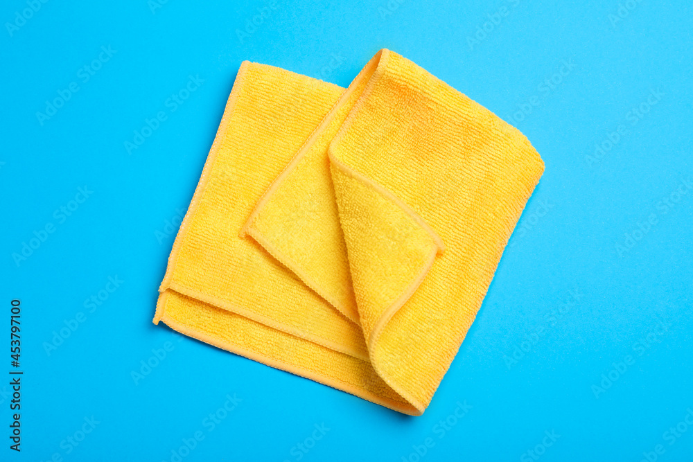 Orange microfiber cloth on light blue background, top view Orange microfiber cloth on light blue background, top view