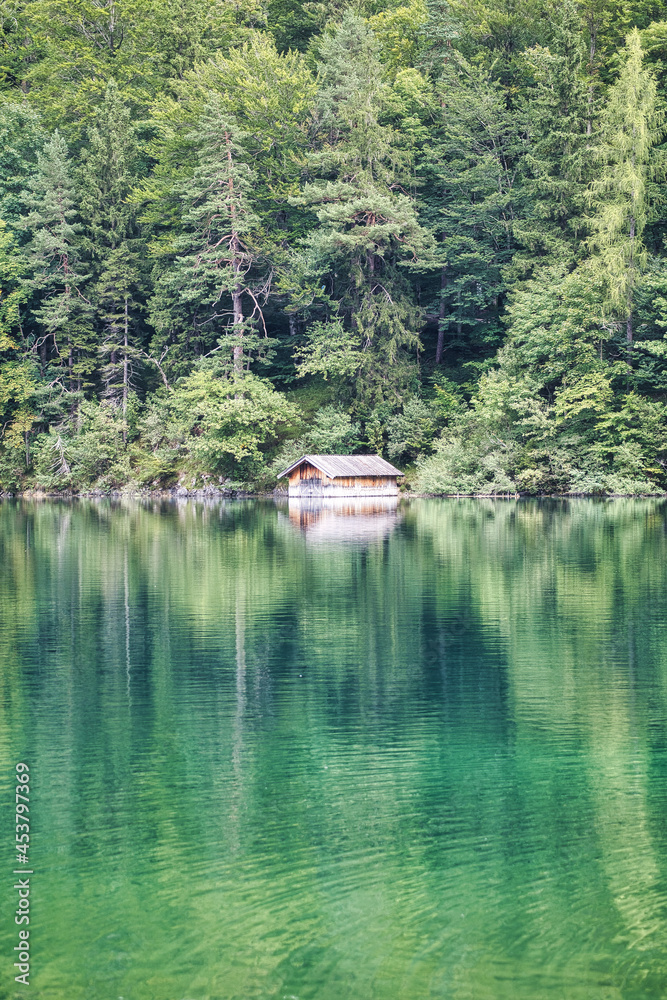 Beautiful green lake with a boats house in the forest and mountains Beautiful green lake with a boats house in the forest and mountains