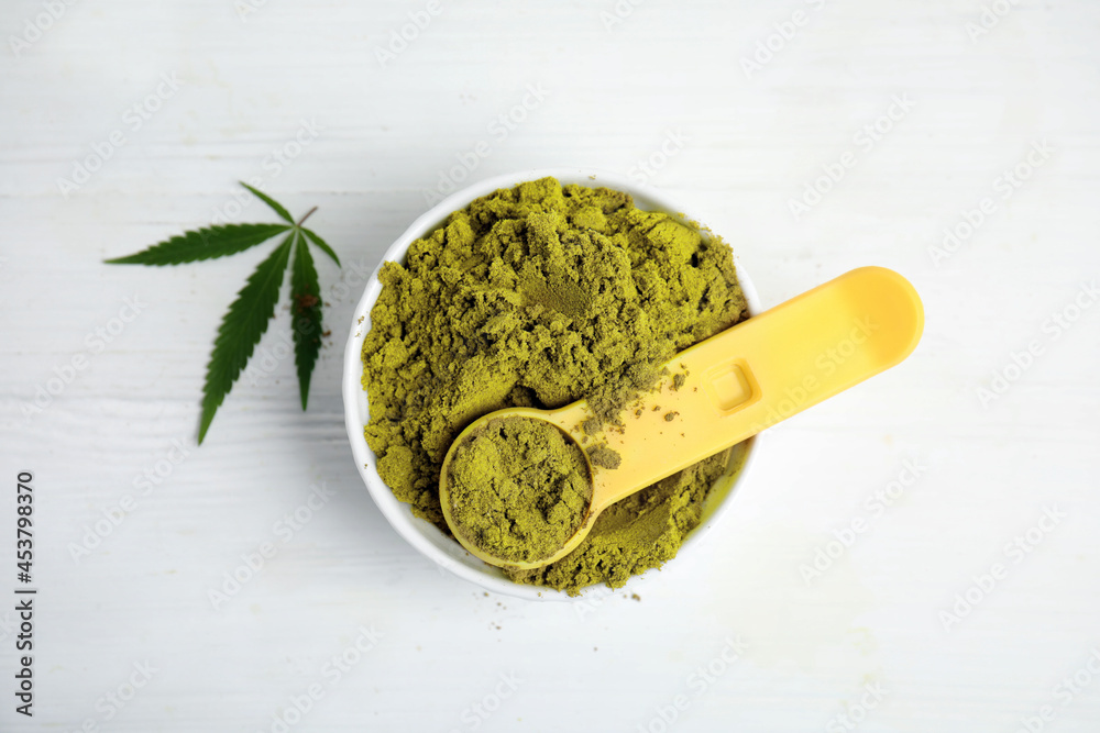 Hemp protein powder and green leaf on white table, flat lay Hemp protein powder and green leaf on white table, flat lay
