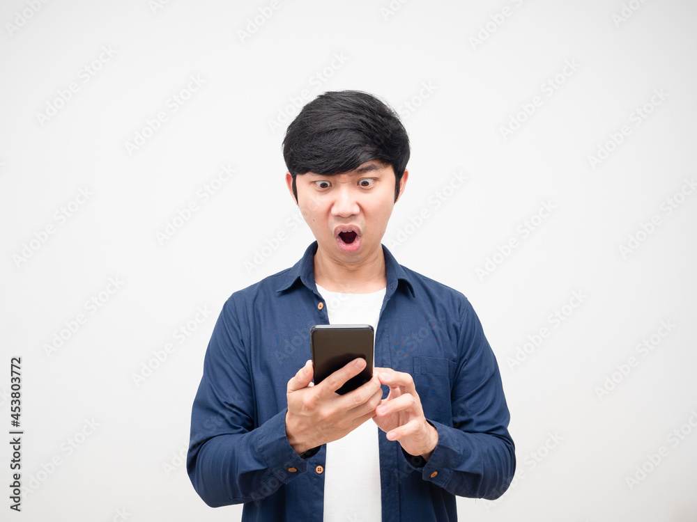 Asian man holding mobile phone and feeling shocked portrait white isolated Asian man holding mobile phone and feeling shocked portrait white isolated