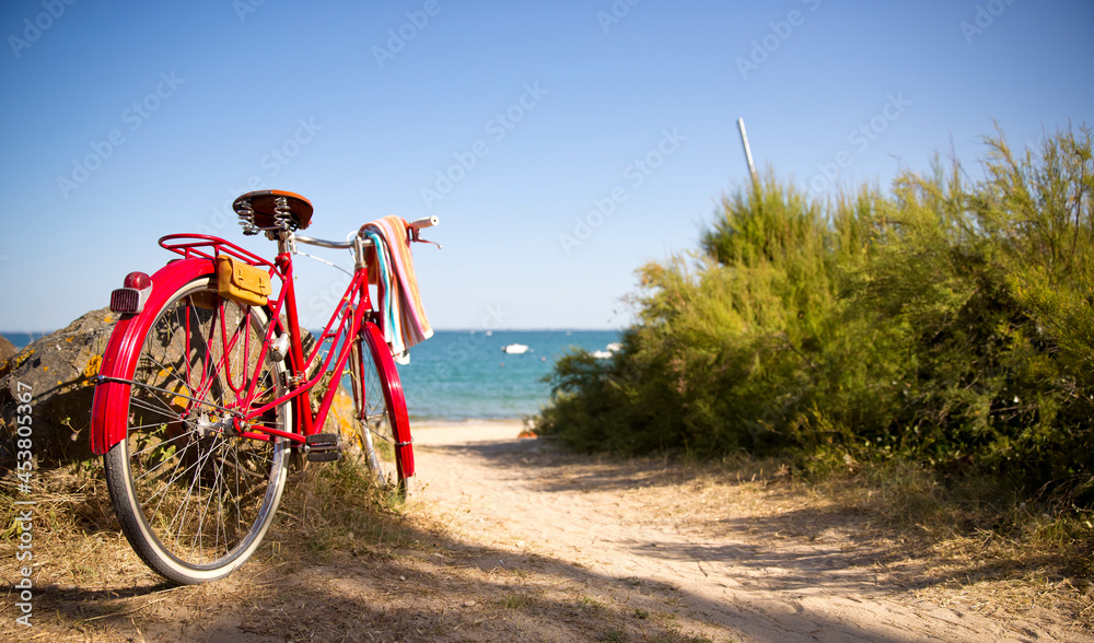 Vieux vélo rouge au bord de la plage et de la mer bleu.