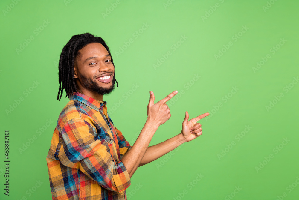 Photo of african guy direct finger empty space promote sale wear plaid shirt isolated green color background