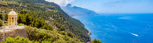 Temple of son marroig sits enthroned on the left side of the coastline of deia above the mediterranean sea in a dreamlike environment, ultra wide shot panorama, copy space at the right side, mallorca photo
