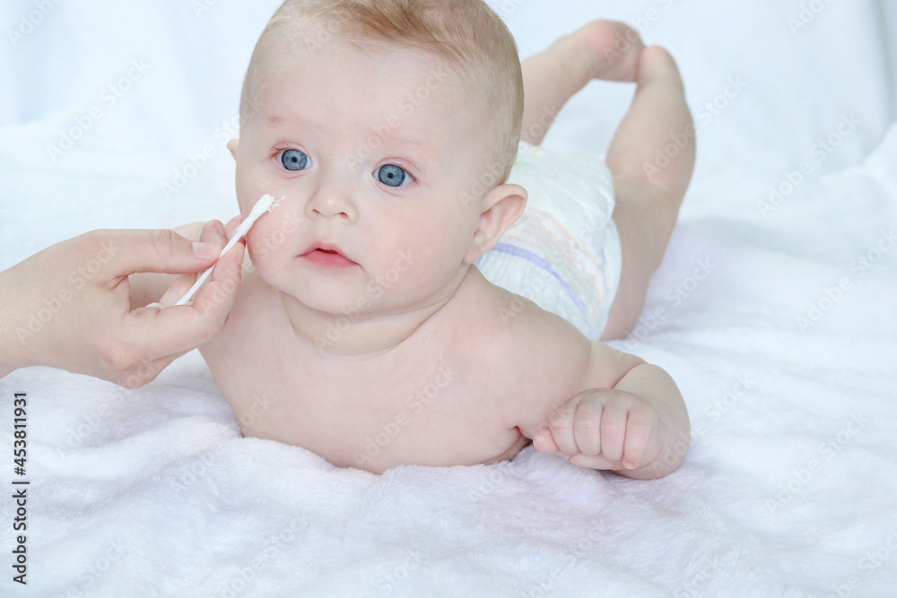 Mom applying moisturizer on baby's face. Healing ointment for baby skin. Care concepts, Appearance, Cleanliness, Dryness, Food allergies, Insect bites, Health, Dermatitis, Tenderness, baby products Mom applying moisturizer on baby's face. Healing ointment for baby skin. Care concepts, Appearance, Cleanliness, Dryness, Food allergies, Insect bites, Health, Dermatitis, Tenderness, baby products