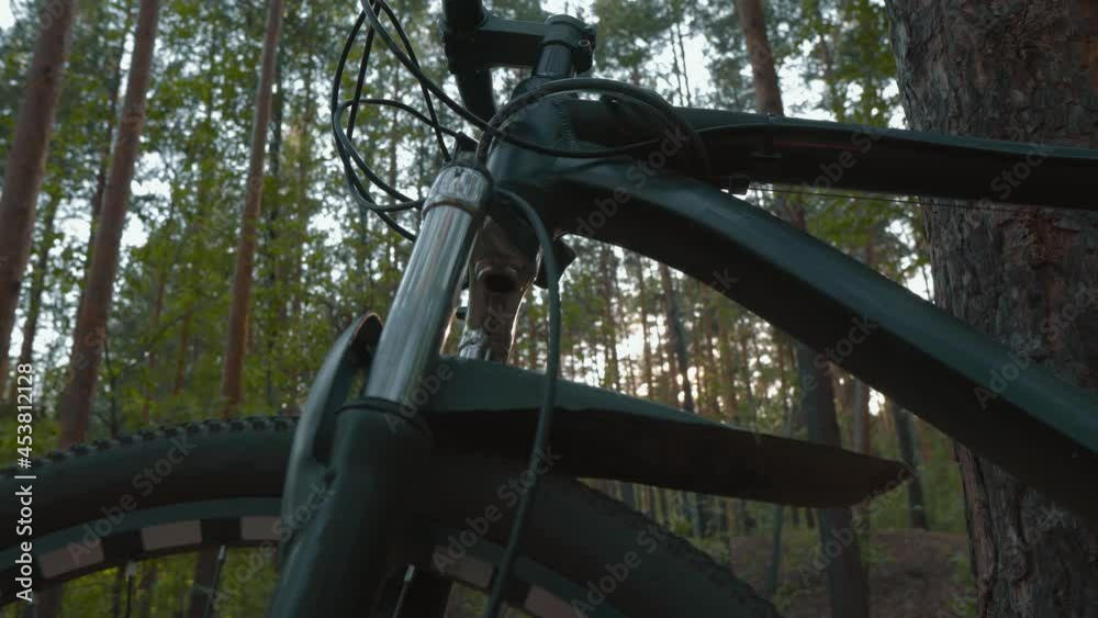Bicycle Frame Close-up, Smooth Camera Downward. Details of a Bicycle Standing in the Forest. Concept of Cycling and Cycling. Free Moving on Free Transport Bicycle Frame Close-up, Smooth Camera Downward. Details of a Bicycle Standing in the Forest. Concept of Cycling and Cycling. Free Moving on Free Transport