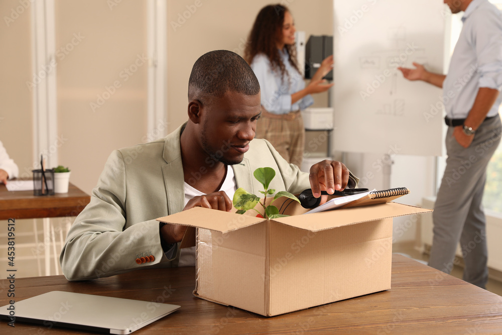 New coworker unpacking box with personal items at workplace in office New coworker unpacking box with personal items at workplace in office