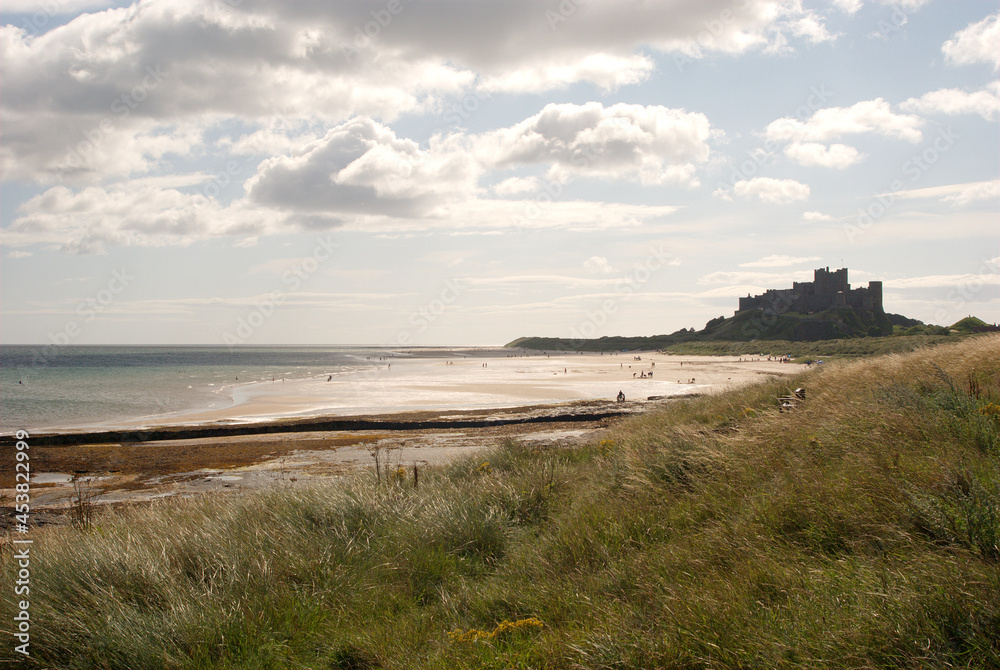 Obraz premium Bamburgh castle and beach in summer sunshine