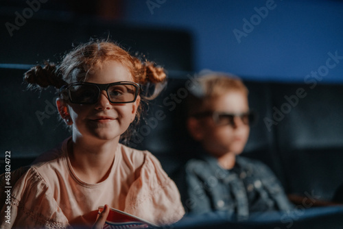 Small children with 3d glasses in the cinema, watching film.