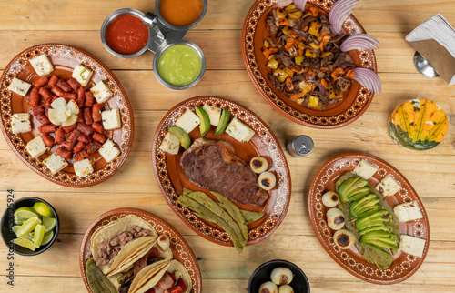 Mexican food served in clay dishes, on a wooden table