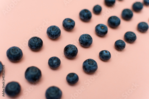Blueberries arranged in rows on an old pink background