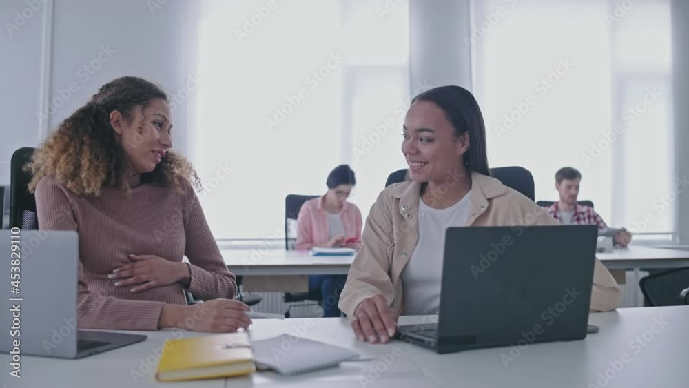 Happy young woman communicating with expecting colleague in coworking space