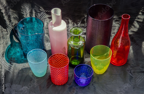 Many Different glass jar and glass cups and surface reflections on a black background. Group of different glassware, Selective focus.