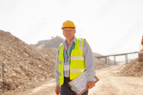 Businessman and worker reading blueprints on site