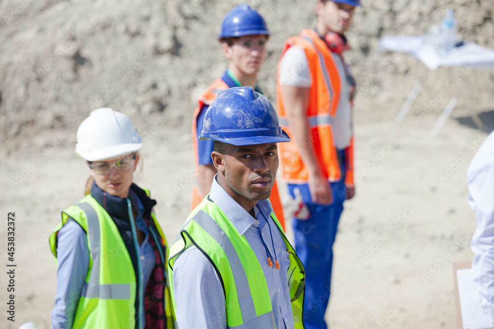 Workers talking with machinery in quarry