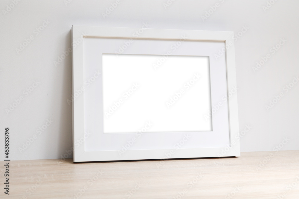 Pusta biała rama na zdjęcia na komodzie oparta o ścianę Stock Photo | Adobe  Stock