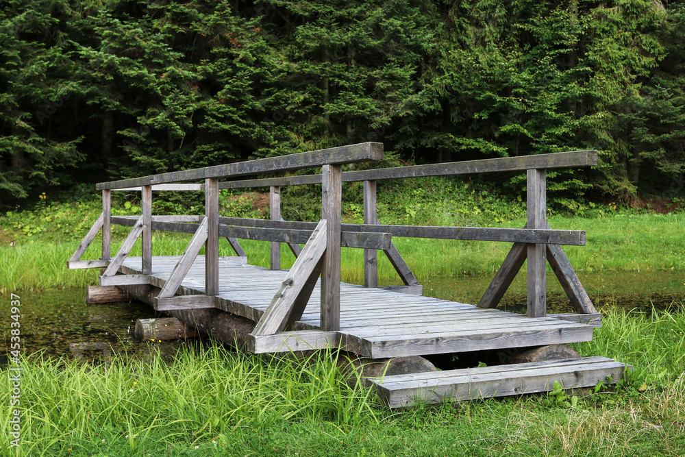 A wooden pier over the lake in the forest. A wooden pier over the lake in the forest.