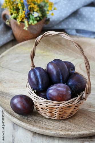 Wicker basket with ripe plums.