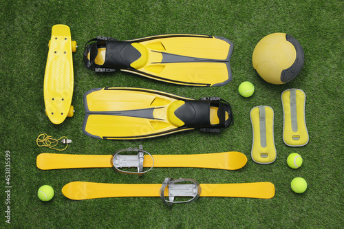 Different sport equipment on green grass, flat lay photo