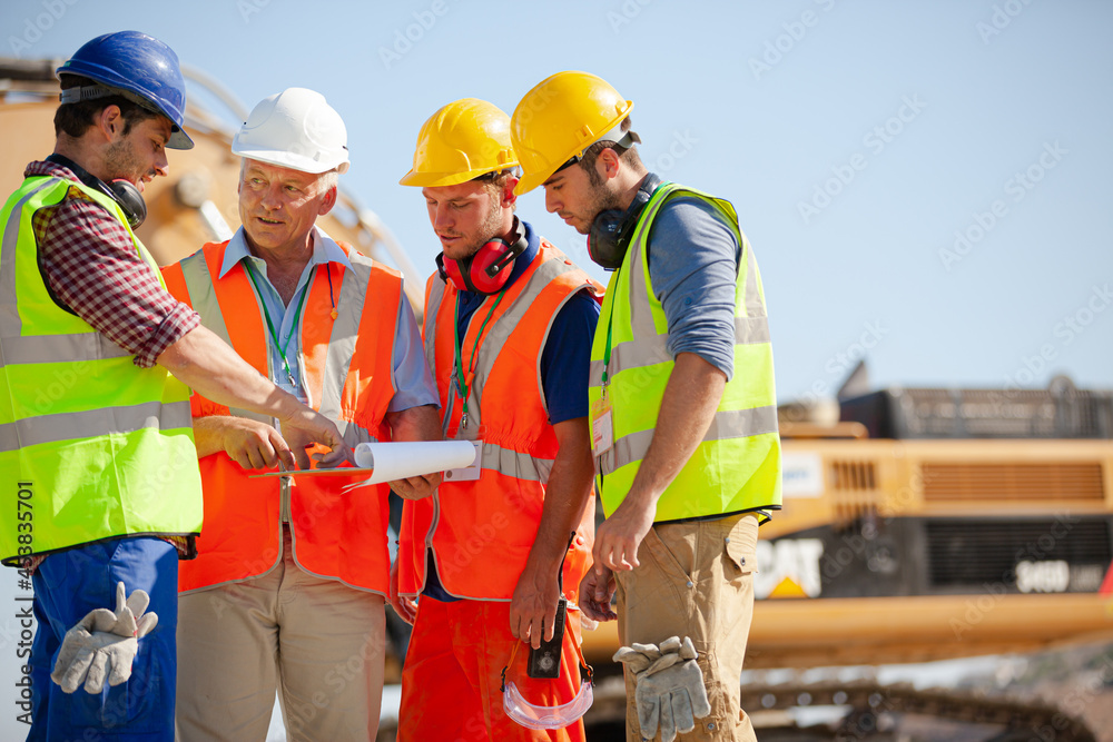 Worker standing on machinery on site Worker standing on machinery on site