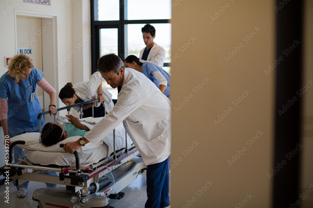 Doctors rushing patient on gurney in hospital corridor Doctors rushing patient on gurney in hospital corridor