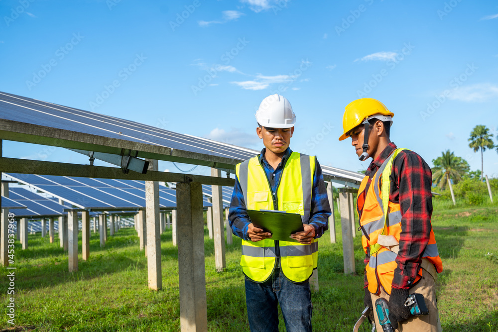 Electrical engineer or technician maintenance electrical system working on checking and maintenance equipment at solar power plant,Clean and green alternative energy concept. Electrical engineer or technician maintenance electrical system working on checking and maintenance equipment at solar power plant,Clean and green alternative energy concept.