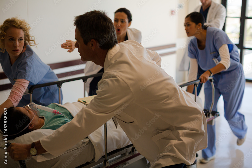 Doctors rushing patient on gurney in hospital corridor