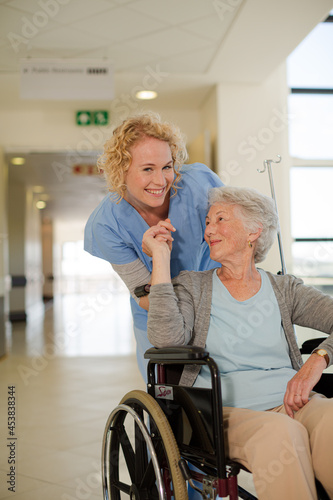 Portrait of smiling nurse and elderly patient in wheelchair
