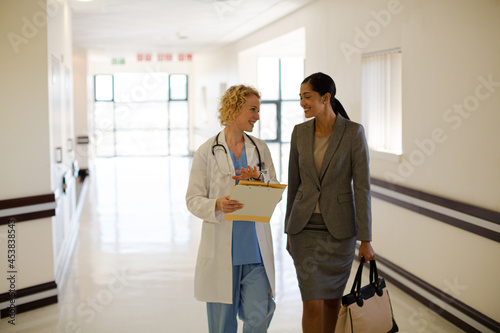 Doctor and businesswoman walking in hospital corridor © KOTO
