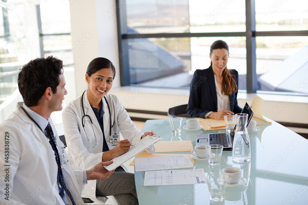 Fototapeta premium Doctors and businesswoman talking in meeting