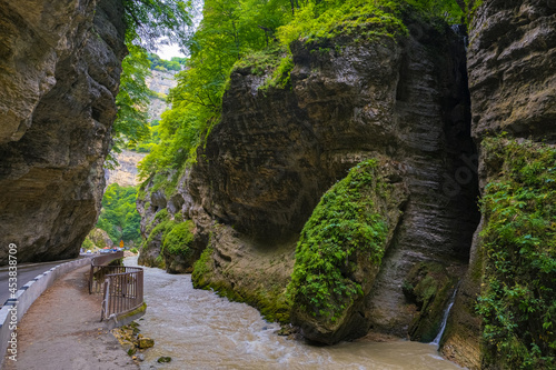 A small waterfall flows into a large mountain river