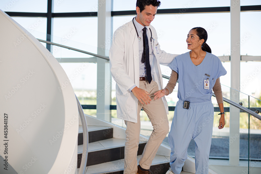 Doctor and nurse handshaking on hospital staircase Doctor and nurse handshaking on hospital staircase