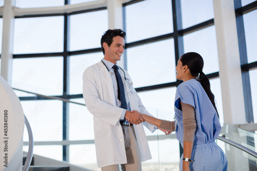 Obraz premium Doctor and nurse handshaking on hospital staircase