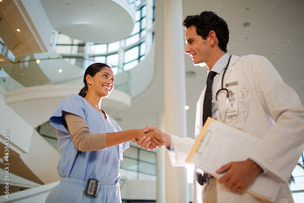 Doctor and nurse handshaking in hospital