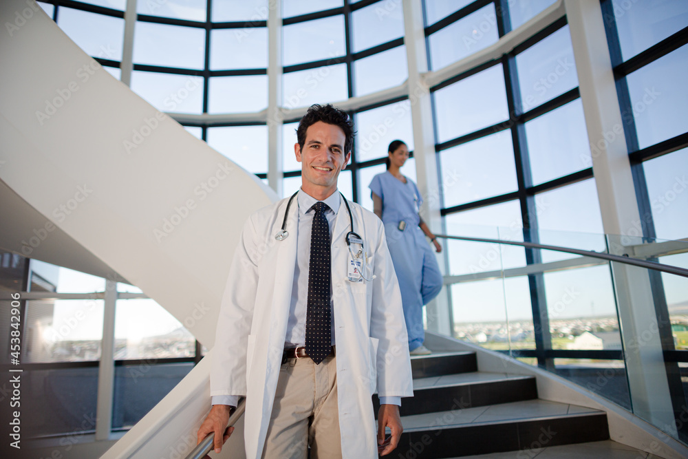 Portrait of smiling doctor on staircase in hospital Portrait of smiling doctor on staircase in hospital