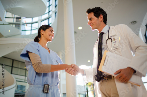 Doctor and nurse handshaking in hospital