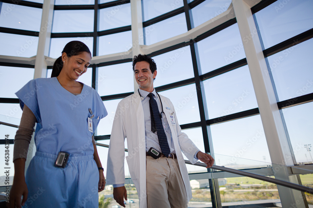 Doctor and nurse talking on staircase Doctor and nurse talking on staircase