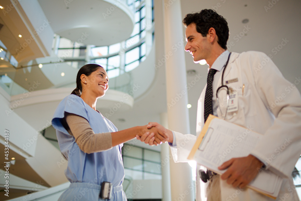 Doctor and nurse handshaking in hospital