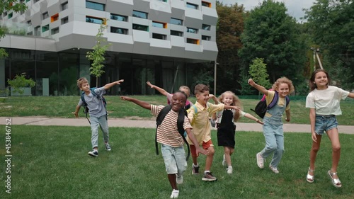 Cheerful multiracial children taking fun on schoolyard photo