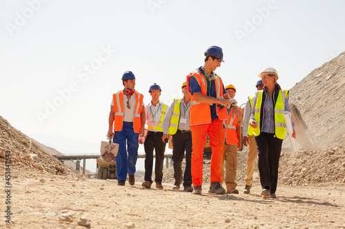 Businessman watching workers in quarry